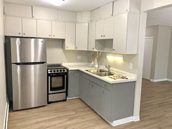 a kitchen with white cabinets and stainless steel appliances